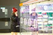 Woman looking at a display in a supermarket while on the phone