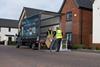 Two delivery drivers unloading a washing machine from a Marks Electrical van