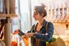 Woman in a shop filling a brown paper bag with cereal