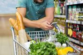 man shopping in supermarket with phone