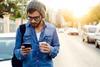 Young man in street with coffee and phone