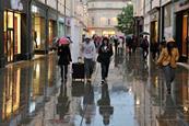 Shoppers walking down a wet high street