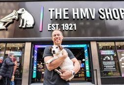 HMV owner Doug Putman poses with a dog outside HMV's Oxford Street store