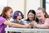 Four-girls-looking-at-a-phone-and-laughing