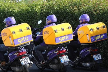 Three Getir delivery drivers on motorbikes shown from behind