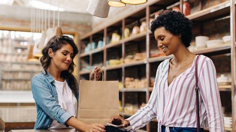 Woman paying at checkout with smartphone digital wallet