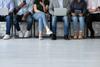 Six people queuing for job interview, seated, shown from head down