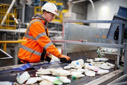 Man sorting recycling at plant