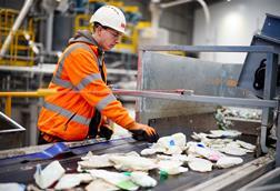 Man sorting recycling at plant