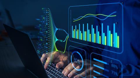 Person typing at a computer with graphics showing charts and stats