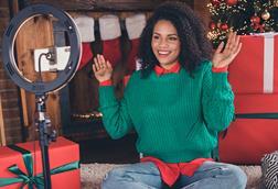 Female influencer filming on phone in front of Christmas tree