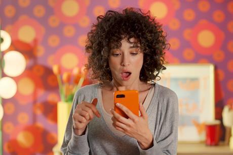 Woman looking at her phone in a Temu advert